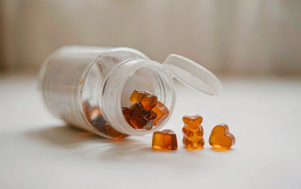 Gummy vitamins sticking together inside an open supplement bottle